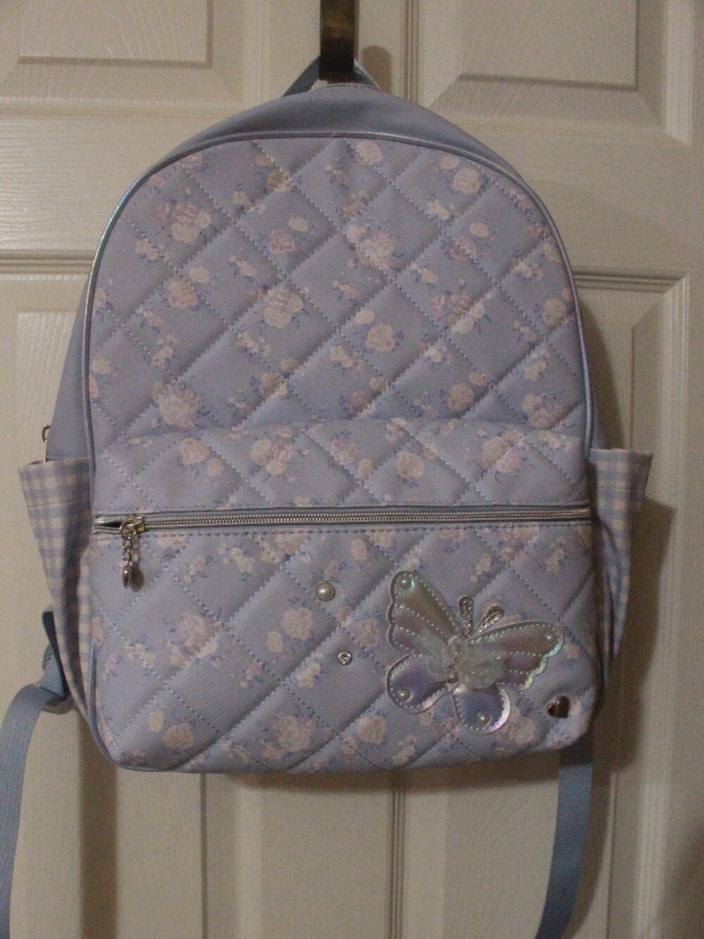 Title: Light Blue Quilted Floral Backpack with Butterfly Accent